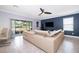 Inviting living area with a large sectional sofa, stylish decor, and sliding glass doors to the backyard at 9056 Wildflower Ln, Kissimmee, FL 34747