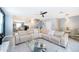 Open-concept living room with a large sectional sofa, modern lighting, and tile flooring at 9056 Wildflower Ln, Kissimmee, FL 34747