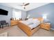 Bedroom with neutral carpet, a ceiling fan, and calming blue walls at 9056 Wildflower Ln, Kissimmee, FL 34747
