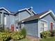 Charming two-story townhome featuring a blue exterior, well-maintained landscaping and a bright red front door at 914 Caribbean Dr, Davenport, FL 33897