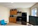 Cozy kitchen features wooden cabinets, modern black appliances, and tiled floors at 914 Caribbean Dr, Davenport, FL 33897