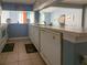 Clean kitchen with white cabinets, tile flooring, and a window to the living room at 914 Caribbean Dr, Davenport, FL 33897