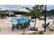 Community pool and lounge area with outdoor table, chairs and palm trees at 914 Caribbean Dr, Davenport, FL 33897