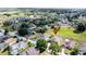 This aerial view shows a home near a golf course in a neighborhood with mature trees at 925 Montana Ave, Davenport, FL 33897