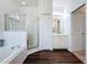Bright bathroom with a walk-in shower, a soaking tub, and wood-look floors at 925 Montana Ave, Davenport, FL 33897