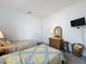 Bright bedroom featuring two beds, dresser, and mounted TV for comfortable living at 925 Montana Ave, Davenport, FL 33897