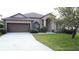 Charming single-story home with a two-car garage and well-manicured lawn at 925 Montana Ave, Davenport, FL 33897