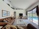 Bright living room featuring vaulted ceilings, neutral walls and carpet, and sliding glass doors to the pool area at 925 Montana Ave, Davenport, FL 33897