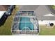 An aerial shot of a screened-in pool and patio area with a jacuzzi, with outdoor seating at 925 Montana Ave, Davenport, FL 33897