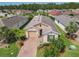 Aerial view of a single Gathering home with a brick driveway, lush landscaping, and well-manicured lawn at 105 Palazzo Ln, Kissimmee, FL 34759