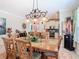 Elegant dining room area with a large table, chandelier lighting and kitchen with stainless appliances in background at 105 Palazzo Ln, Kissimmee, FL 34759