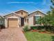 A charming single-Gathering home featuring lush landscaping, brick driveway and covered entry at 105 Palazzo Ln, Kissimmee, FL 34759