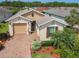 A charming single-Gathering home featuring lush landscaping, brick driveway and covered entry at 105 Palazzo Ln, Kissimmee, FL 34759