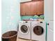 Laundry room with washer, dryer, cabinets, and whimsical bubble decor at 105 Palazzo Ln, Kissimmee, FL 34759