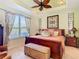 Bright main bedroom features a tray ceiling, large window, and comfortable furnishings at 105 Palazzo Ln, Kissimmee, FL 34759