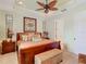 Relaxing main bedroom featuring a tray ceiling, comfortable furnishings, and an ensuite bathroom at 105 Palazzo Ln, Kissimmee, FL 34759
