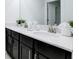 Bathroom with double sinks, dark cabinets, quartz countertop and modern faucets at 1058 Splash Shot Pl, Davenport, FL 33896