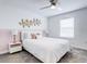 Bedroom with a queen bed, ceiling fan, and a decorative wall art at 1058 Splash Shot Pl, Davenport, FL 33896