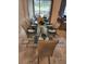 Elegant dining area set for a meal, with a glass table and contemporary furnishings at 1058 Splash Shot Pl, Davenport, FL 33896