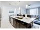 Bright kitchen features a large island with a stainless sink and modern pendant lighting at 1058 Splash Shot Pl, Davenport, FL 33896