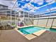 Backyard pool features turquoise water, seating and grilling area in a screened enclosure at 1058 Splash Shot Pl, Davenport, FL 33896