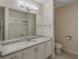 Clean bathroom featuring a granite countertop, large mirror and tiled floors at 1231 Wright Cir # 108, Kissimmee, FL 34747