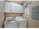 Functional laundry area with washer, dryer, and storage cabinets above at 1231 Wright Cir # 108, Kissimmee, FL 34747