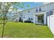 Fenced backyard of a two story home with a lush green lawn and a covered patio area at 12379 Turtle Grass Dr, Orlando, FL 32824