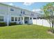 Well-kept backyard with a lush green lawn, a covered patio, and a white privacy fence at 12379 Turtle Grass Dr, Orlando, FL 32824