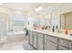 Bright bathroom featuring double vanity, tiled floor, a tub and a shower at 12379 Turtle Grass Dr, Orlando, FL 32824