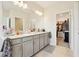 Bathroom featuring double vanity, tiled floor, and a walk-in closet at 12379 Turtle Grass Dr, Orlando, FL 32824