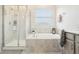 Bright bathroom with a shower, a tub, and a large window at 12379 Turtle Grass Dr, Orlando, FL 32824