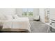 Well-lit bedroom with plush white bedding, carpet flooring, and a window view at 12379 Turtle Grass Dr, Orlando, FL 32824