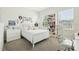 Bright bedroom with a large window and a bookshelf filled with books and decorations at 12379 Turtle Grass Dr, Orlando, FL 32824