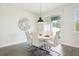Dining area with modern white table, stylish chairs, and a sliding glass door leading to the outdoors at 12379 Turtle Grass Dr, Orlando, FL 32824