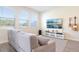 Bright living room with large windows, a plush sofa, and a wall-mounted television for relaxation at 12379 Turtle Grass Dr, Orlando, FL 32824