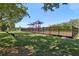 Community playground area with swings, slides, and climbing structures, all enclosed by a secure fence on a green lawn at 12379 Turtle Grass Dr, Orlando, FL 32824