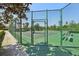 Gated tennis court with green surface, surrounded by fencing at 12379 Turtle Grass Dr, Orlando, FL 32824