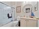 Neat bathroom with tiled tub/shower, sleek white vanity, and nautical decor at 1303 Artisan E Ave, Celebration, FL 34747