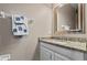 Bathroom with granite countertop, white vanity, and a framed mirror at 1303 Artisan E Ave, Celebration, FL 34747