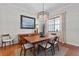 Bright dining room features a wooden table with chairs, an elegant light fixture and a window providing natural light at 1303 Artisan E Ave, Celebration, FL 34747