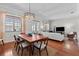 Open-concept dining room features a wooden table with chairs, view of the living room and an elegant light fixture at 1303 Artisan E Ave, Celebration, FL 34747