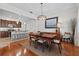 Dining room with a wooden table and chairs, view of the kitchen, modern lighting, and hardwood floors at 1303 Artisan E Ave, Celebration, FL 34747