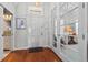 Welcoming foyer with hardwood floors, glass French doors, and a glimpse of a bathroom at 1303 Artisan E Ave, Celebration, FL 34747