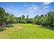 Green space surrounded by trees and walking path on a sunny day at 1303 Artisan E Ave, Celebration, FL 34747
