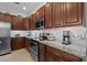 Kitchen features stainless steel appliances, granite countertops, tiled backsplash, and wooden cabinets at 1303 Artisan E Ave, Celebration, FL 34747