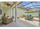 Enclosed patio space with wicker chair, ceiling fan, table, umbrella, brick floor and ample potted plants at 1303 Artisan E Ave, Celebration, FL 34747