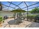Covered patio space with table, chairs, umbrella, BBQ and enclosed by screen at 1303 Artisan E Ave, Celebration, FL 34747