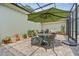 View of the enclosed patio space with an umbrella over a table and ample plants at 1303 Artisan E Ave, Celebration, FL 34747