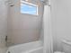 A bathtub and shower combo featuring white subway tile, chrome fixtures and bright natural light at 13282 Bromborough Dr, Orlando, FL 32832